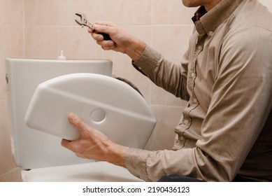 Empleador profesional o propietario reparando la cisterna del inodoro en el retrete, foto de primer plano
