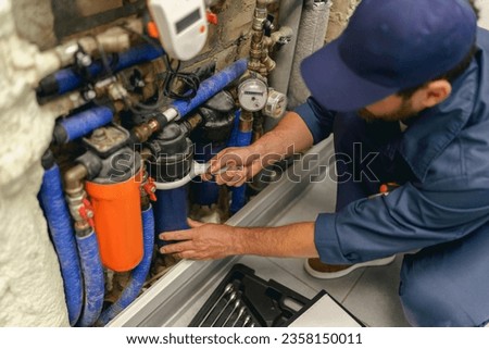Professional plumber repairing water supply system at home uses a special tools