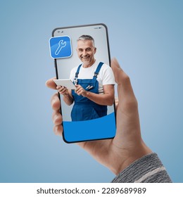 Professional plumber and repairman on smartphone screen: hire contractors online - Powered by Shutterstock