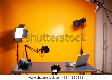 Professional podcast and vlogging setup in studio with yellow background.