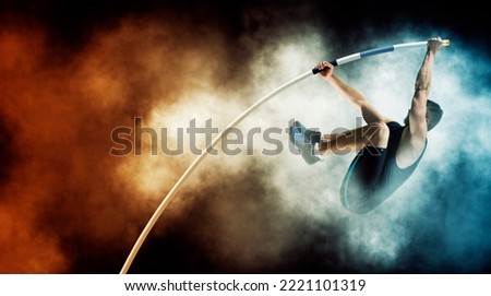 Professional pole vaulter training on smoke background. Copy space background