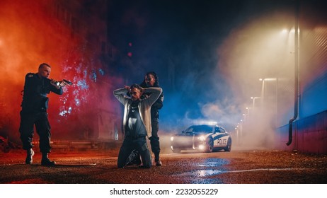 Professional Police Officer Aim at a Suspect While Black Female Deputy Handcuffs him. Fellon Putting Hands on Head in Compliance. Police Successfully Making an Arrest - Powered by Shutterstock