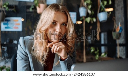 Professional Portrait of a Happy Woman with Layered Hair and Electric Blue Blazer, Sitting in the City Street, Wearing Stylish Jewellery and Eyewear