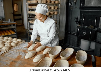 Professional positive woman baker forming loaf from raw dough - Powered by Shutterstock