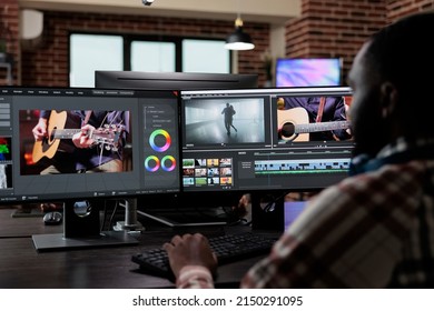 Professional post production editor doing footage montage and visual improvement. Creative agency office employee sitting at multi monitor workstation while editing graphic content on computer.