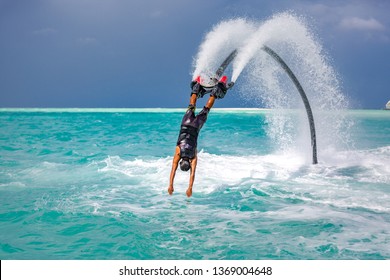 Professional pro fly board rider in tropical sea, water sports concept background. Summer extreme sports, silhouette of a fly board rider at sea