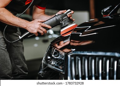 Professional process of detailing car in car studio, hands with orbital polisher, scratching remover, vehicle care concept