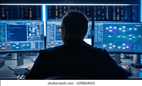 Professional IT Programer Working in Data Center on Desktop Computer with Three Displays, Doing Development of Software and Hardware. Displays Show Blockchain, Data Network Architecture Concept