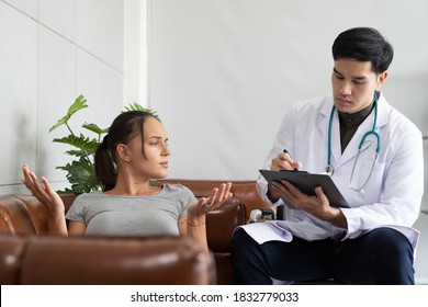 Professional psychologist male making notes and talking to stressful woman patient while her lying on sofa in the hospital or clinic. health, people and treatment concept - Shutterstock ID 1832779033