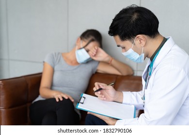 Professional Psychologist Male Wearing Protective Medical Face Mask Conducting A Consultation And Making Notes While Talking To Stressful Woman In Face Mask During Coronavirus Or COVID 19 Outbreak