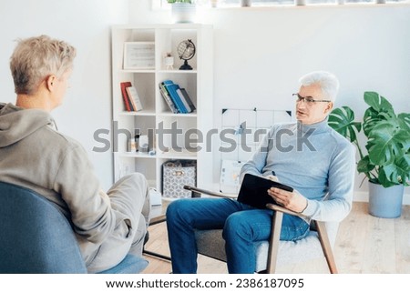 Professional psychotherapy. Male psychologist having session with male patient at mental health clinic, Taking Notes During Appointment In Office. Psychological help service. Treatment of depression