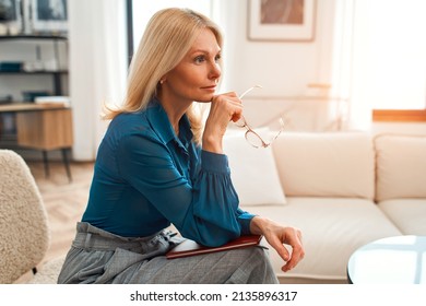 Professional Psychotherapy. Successful Elegant Psychologist Aged Woman Holding A Folder Sitting On An Armchair In The Office.