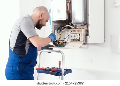 Professional Qualified Engineer Servicing A Natural Gas Boiler At Home