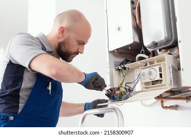 Professional Qualified Engineer Servicing A Natural Gas Boiler At Home