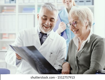 Professional radiologist examining an x-ray image with a senior patient during a visit at the clinic, the doctor is pointing and giving advices - Powered by Shutterstock