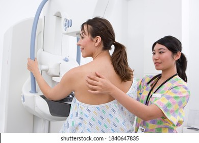 A professional radiologist helping and attending a patient on a mammogram machine in the radiology department