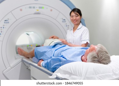 A Professional Radiologist Smiling At The Patient While Helping Him With An MRI Scan