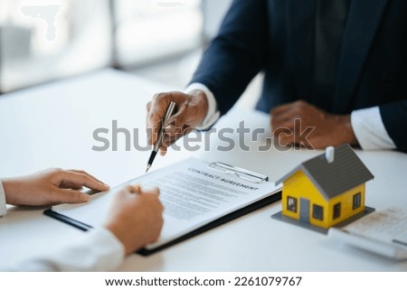 Professional real estate agent guiding and explaining the document process to the customer before the deal was done.