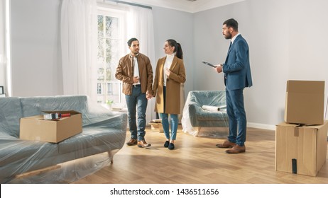 Professional Real Estate Agent Shows Bright New Apartment to a Young Couple. Successful Young Couple Ready to Become Homeowners. Spacious Bright Home with Big Windows. - Shutterstock ID 1436511656