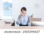 Professional receptionist talking on phone in office