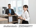 Professional receptionist working with client in office