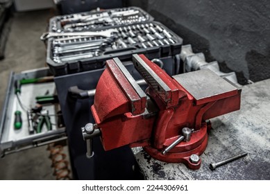 Professional red metal vice tool in a garage workshop