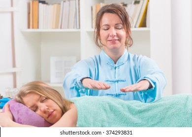 Professional Reiki Healer Doing Reiki Treatment To Young Woman