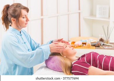 Professional Reiki Healer Doing Reiki Treatment To Young Woman