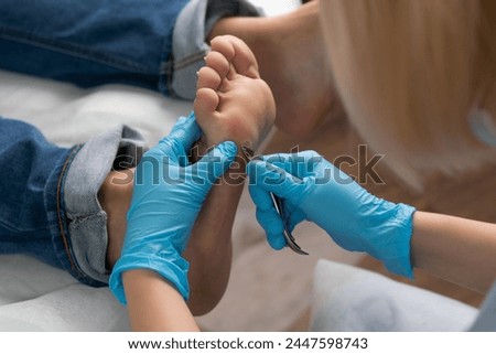 Professional removing a callus on a womans foot by nippers at clinic. 