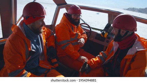 Professional rescuers in orange uniform sitting in boat and talking. Portrait of rescue service team resting inside boat patrolling coastline in winter - Shutterstock ID 1954394881
