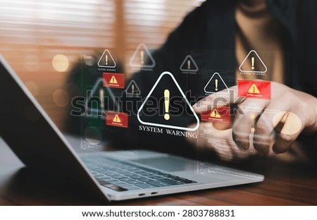 IT professional responding to critical system warning alerts on a laptop, illustrating cyber incident response, infrastructure monitoring, network defense, security operations, threat detection