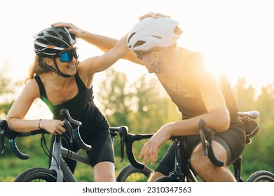 Motociclistas profesionales en ciclismo de carreras por carretera. Estilo de vida activo y concepto deportivo. Un par de ciclistas deportivos tomando un descanso mientras se sostienen el casco. Copiar espacio.