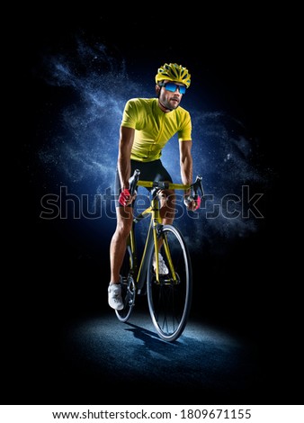 Professional road bicycle racer in action isoated on the black background