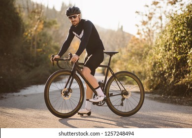 Professionelles Fahrradrennen posieren. Männer fahren Mountainbike bei Sonnenuntergang.