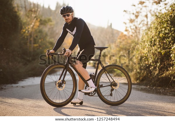 プロのロードレーサーのポーズ 日没に自転車を乗る男性 の写真素材 今すぐ編集