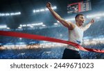 Professional Runner Competing In National Championship. A strong Caucasian Male Athlete is Sprinting Towards the Line in a Crowded Stadium, Crossing the Race Finish with His Hands in the Air