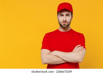 Professional Sad Disappointed Delivery Guy Employee Man In Red Cap T-shirt Uniform Workwear Work As Dealer Courier Hold Hands Crossed Folded Isolated On Plain Yellow Background Studio. Service Concept