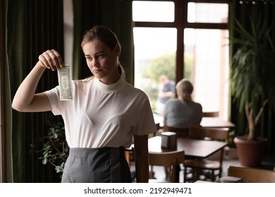 Professional Sad Waiter In Restaurant With Tips. Little Money From Cafe Customer. The Concept Of Service.