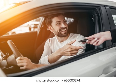 Professional Salesperson During Work With Customer At Car Dealership. Giving Keys To New Car Owner.