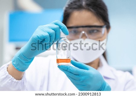 Professional scientist holding solution bottle for test coliform or bacteria in water and ice at chemistry laboratory.