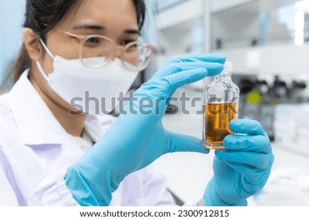 Professional scientist holding solution bottle for test coliform or bacteria in water and ice at chemistry laboratory.