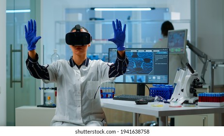 Professional scientist wearing virtual reality glasses using medical inovation in lab. Team of researchers working with equipment device, future, medicine, healthcare, professional, vision, simulator - Shutterstock ID 1941638758