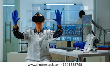 Professional scientist wearing virtual reality glasses using medical inovation in lab. Team of researchers working with equipment device, future, medicine, healthcare, professional, vision, simulator