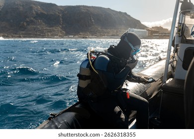 Professional scuba diver preparing for diving, adjusting equipment and checking compass on inflatable boat