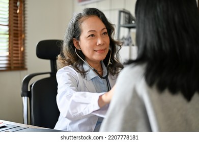 A Professional Senior Asian Female Doctor Cardiologist Checks Up, Using A Stethoscope To Listen To Breath In The Examination Room. Medical Checkup Concept