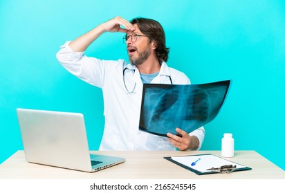 Professional senior dutch traumatologist in office doing surprise gesture while looking to the side
