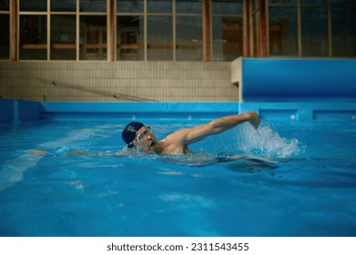 Professional senior man swimmer doing exercise in indoor swimming pool - Powered by Shutterstock