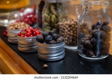 Professional set of gin spices in small bottles, pink pepper, hibiscus flowers, juniper berries, cardamom and coriander seeds close up - Powered by Shutterstock