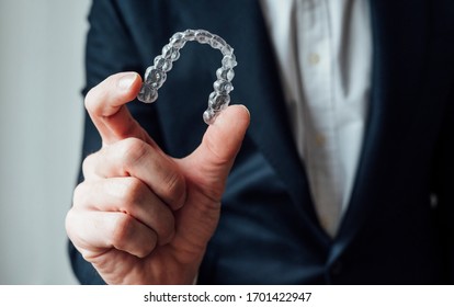 Professional showing dental clear aligners.