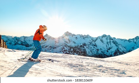 Professional Skier Athlete Skiing At Sunset On Top Of French Alps - Winter Vacation And Sport Concept With Adventure Guy On Mountain Ski Resort Riding Down The Slope - Bright Sunshine Filter